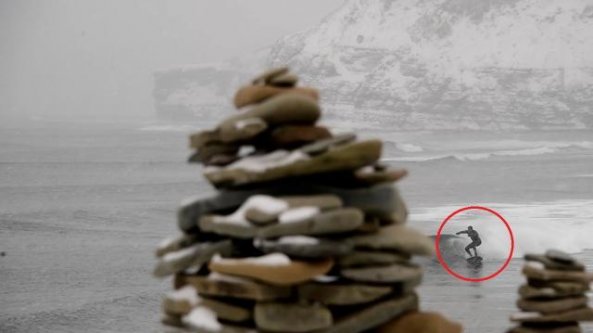 Le temperature glaciali non spaventano il surfista: in acqua durante la bufera di neve