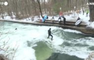 Con il freddo e la neve i surfisti cavalcano le onde del fiume
