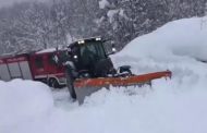 Il trattore lotta con la neve per trainare il camion dei Vigili del fuoco    