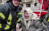 Anziani vengono soccorsi dai vigili del fuoco tra le fiamme dopo il bombardamento di un palazzo a Kiev